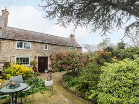 A cottage surrounded by greenery and a seating area at The Annexe at Cherry Cottage in Upton St Leonards