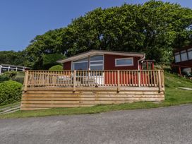A house with a deck and garden at Chalet 47 Erw Porthor in Tywyn