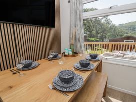 A dining table set with plates and glasses at Chalet 47 Erw Porthor, Tywyn