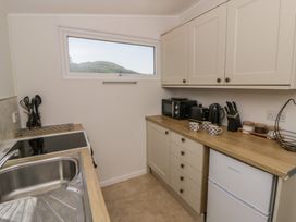 A kitchen with a sink, stove and appliances at Chalet 47 Erw Porthor in Tywyn