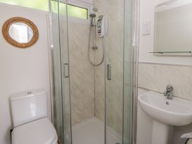 A bathroom featuring a shower, toilet, and sink at Chalet 47 Erw Porthor Tywyn