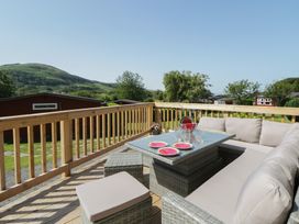An outdoor seating area with a table and couch at Chalet 47 Erw Porthor Tywyn