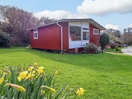 A house with windows and grass at Chalet 23 Erw Porthor Tywyn