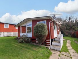 A house with a bush and a pathway at Chalet 23 Erw Porthor Tywyn