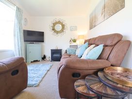 A living room with a sofa and television at Chalet 23 Erw Porthor in Tywyn
