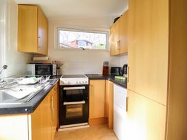 A kitchen with a sink, oven, microwave, and cupboards at Chalet 23 Erw Porthor Tywyn
