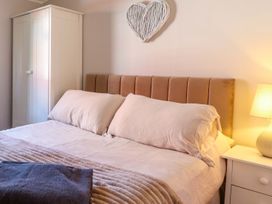 A bedroom with a bed and wardrobe at Chalet 23 Erw Porthor in Tywyn
