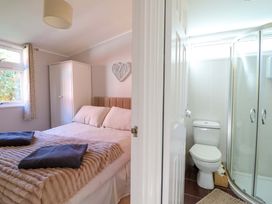 A bedroom with bed and en-suite bathroom at Chalet 23 Erw Porthor Tywyn