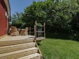 An outdoor deck with chairs and a table at Chalet 23 Erw Porthor in Tywyn