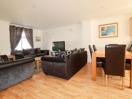 A living room with sofa and dining area at 62 Golf Lodges Atlantic Reach near Fraddon
