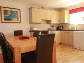 A kitchen with a dining table and chairs at 62 Golf Lodges Atlantic Reach near Fraddon