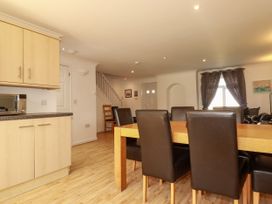 A dining room with a kitchen unit and dining table at 62 Golf Lodges, Atlantic Reach near Fraddon