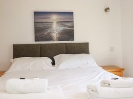 A bedroom with a double bed and wall art at 62 Golf Lodges Atlantic Reach near Fraddon