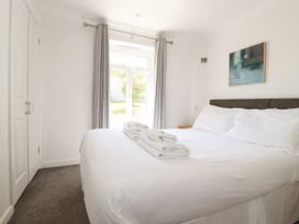 A bedroom with a bed and window at 62 Golf Lodges in Atlantic Reach near Fraddon