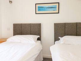 A bedroom with two single beds and a painting at 62 Golf Lodges, Atlantic Reach near Fraddon