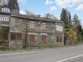 A stone building with windows along the road at Wilders Wood Windermere