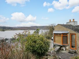 A house near a lake with trees and bushes at Wilders Wood in Windermere