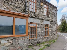 A stone building with windows and a pathway at Wilders Wood in Windermere