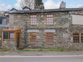 An exterior view of a stone house with multiple windows at Wilders Wood in Windermere
