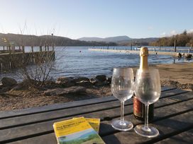 A table with champagne and two glasses overlooking the lake at Wilders Wood Windermere