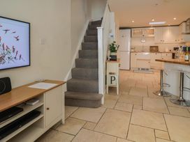 A kitchen with a staircase and television at Phoenix Cottage in Lyme Regis