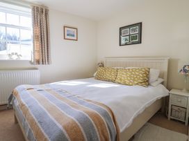 A bedroom with a bed and bedside table at Phoenix Cottage in Lyme Regis