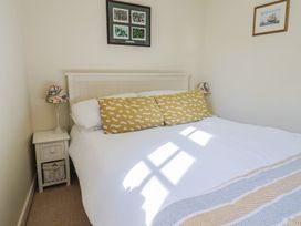 A bedroom with a bed and wall art at Phoenix Cottage Lyme Regis