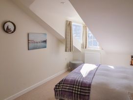 A bedroom with a bed and window at Phoenix Cottage in Lyme Regis