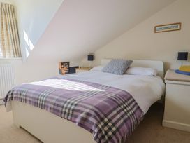 A bedroom with a bed and nightstand at Phoenix Cottage in Lyme Regis