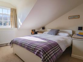 A bedroom with a bed and lamp at Phoenix Cottage in Lyme Regis
