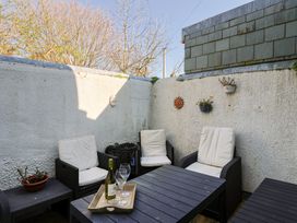 An outdoor patio with seating and a table at Phoenix Cottage in Lyme Regis