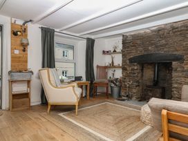 A living room featuring a stone fireplace and wooden furniture at Bedford Cottage in Yelverton