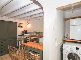 A kitchen with a dining table and appliances at Bedford Cottage in Yelverton