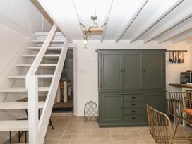 A kitchen with a cupboard and dining area at Bedford Cottage in Yelverton