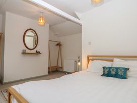 A bedroom with a bed and mirror at Bedford Cottage in Yelverton