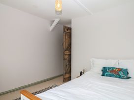 A bedroom with a bed and a wooden door at Bedford Cottage Yelverton