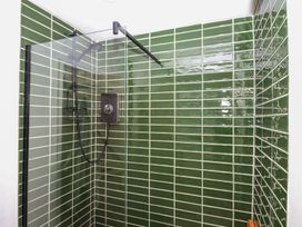A shower with green tiles at Bedford Cottage in Yelverton