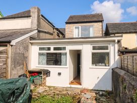 An outdoor view of a building with windows and a stone pathway at Bedford Cottage in Yelverton
