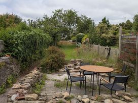 A garden with a table and chairs at Bedford Cottage in Bere Alston