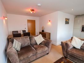 A living room with a sofa and dining area at Apartment 12