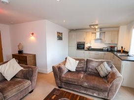 A living room with a sofa and kitchen units at Apartment 12