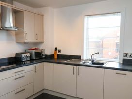 A kitchen with cabinets and appliances at Apartment 12