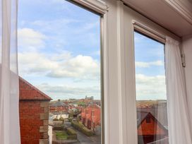 A view through a window showing rooftops and a cloudy sky at Apartment 12 in 