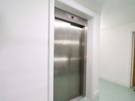 An elevator with a button panel in a corridor at Apartment 12