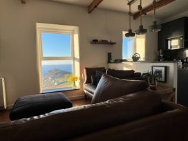 A living room with a window overlooking the sea at Cape View Cape Cornwall near St Just