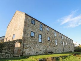 A stone building with windows and benches at Cape View near St Just
