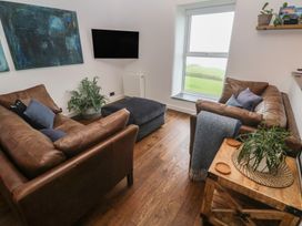 A living room with a sofa and footstool at Cape View Cape Cornwall near St Just
