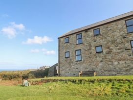 A stone building with windows and a bench at Cape View near St Just