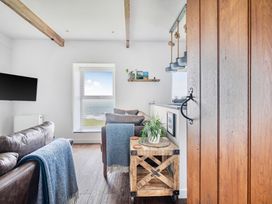 A living room with a sofa and window view at Cape View Cape Cornwall near St Just