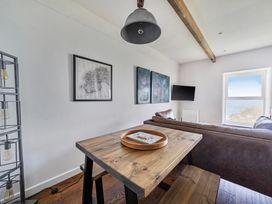 A living room with a table and sofa at Cape View near St Just